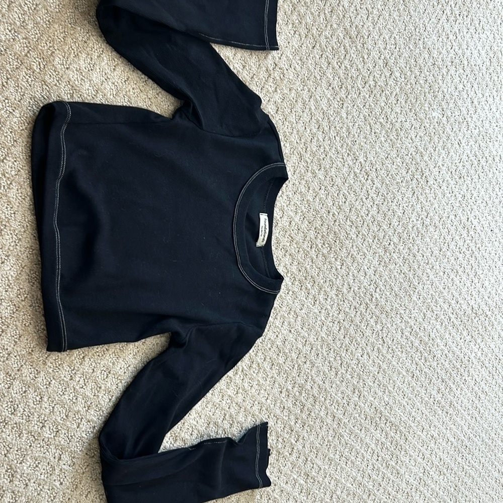 A black The Mia Top with long flowing sleeves